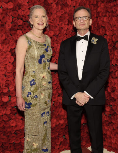 Met Gala dress in front of red flowers